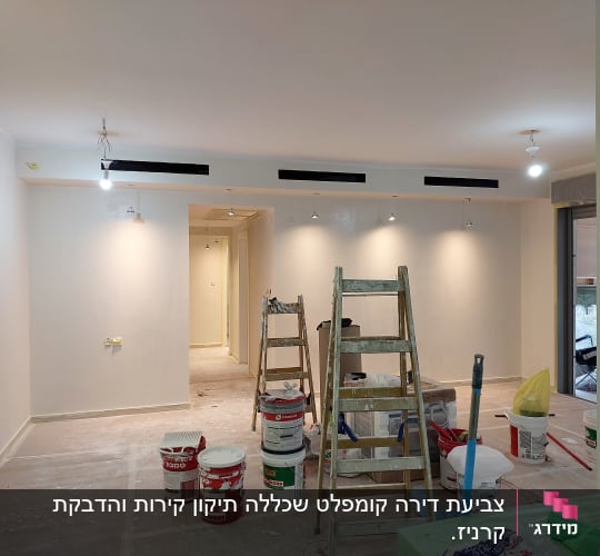 סולמות ודליי צבע בחדר צבוע בלבן